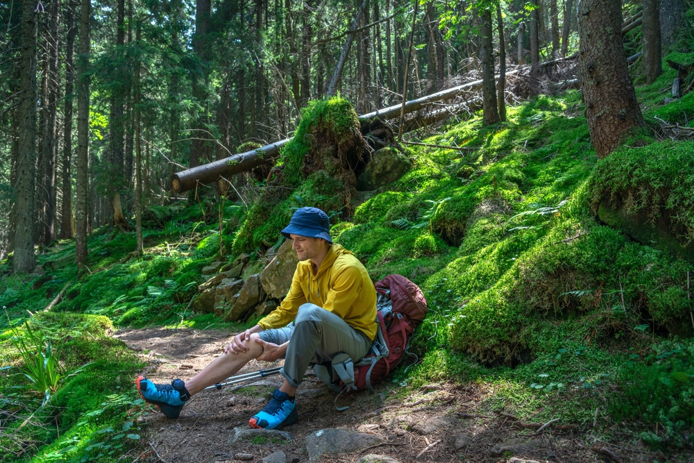 Knee,Injury,On,Hiking,Outdoors,In,Forest.,Man,Holding,Knee